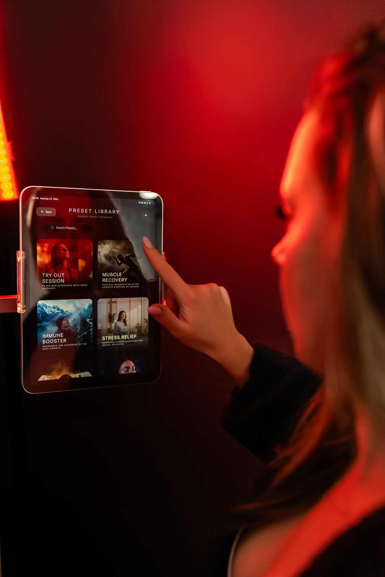Frau wählt auf einem Tablet die Option Muscle Recovery aus einer Preset Library aus.