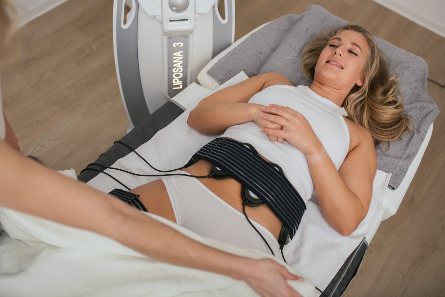 Woman relaxing on a couch with an electrode belt on her abdomen