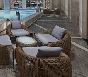 Hotel spa with rattan lounge chairs in front of an illuminated pool