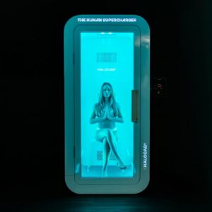 Woman sitting relaxed in a turquoise-lit HALOCAB® cabin